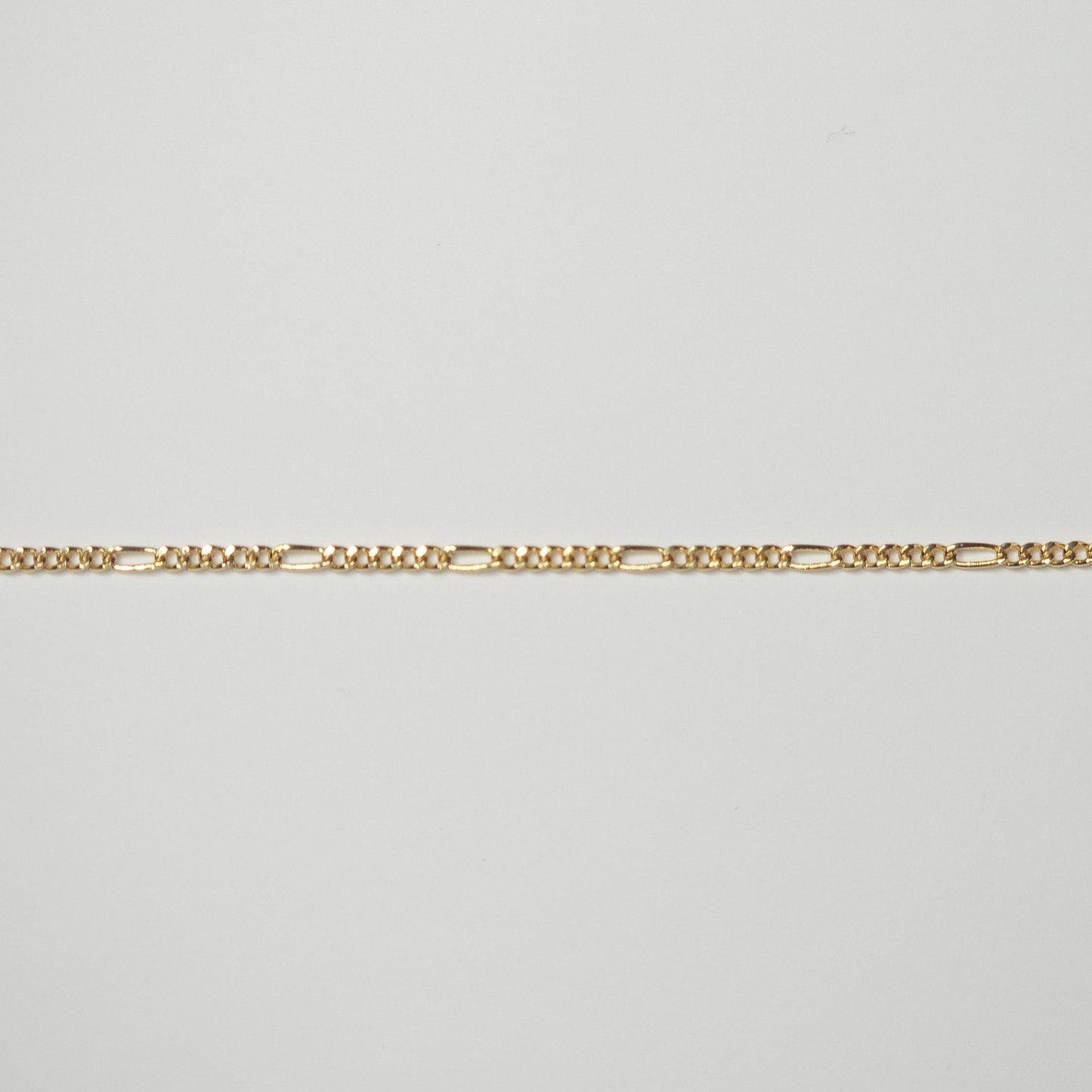 Medium-width Figaro chain in durable gold filled metal, with reflective links that combine timeless Italian styling and spiritual symbolism.