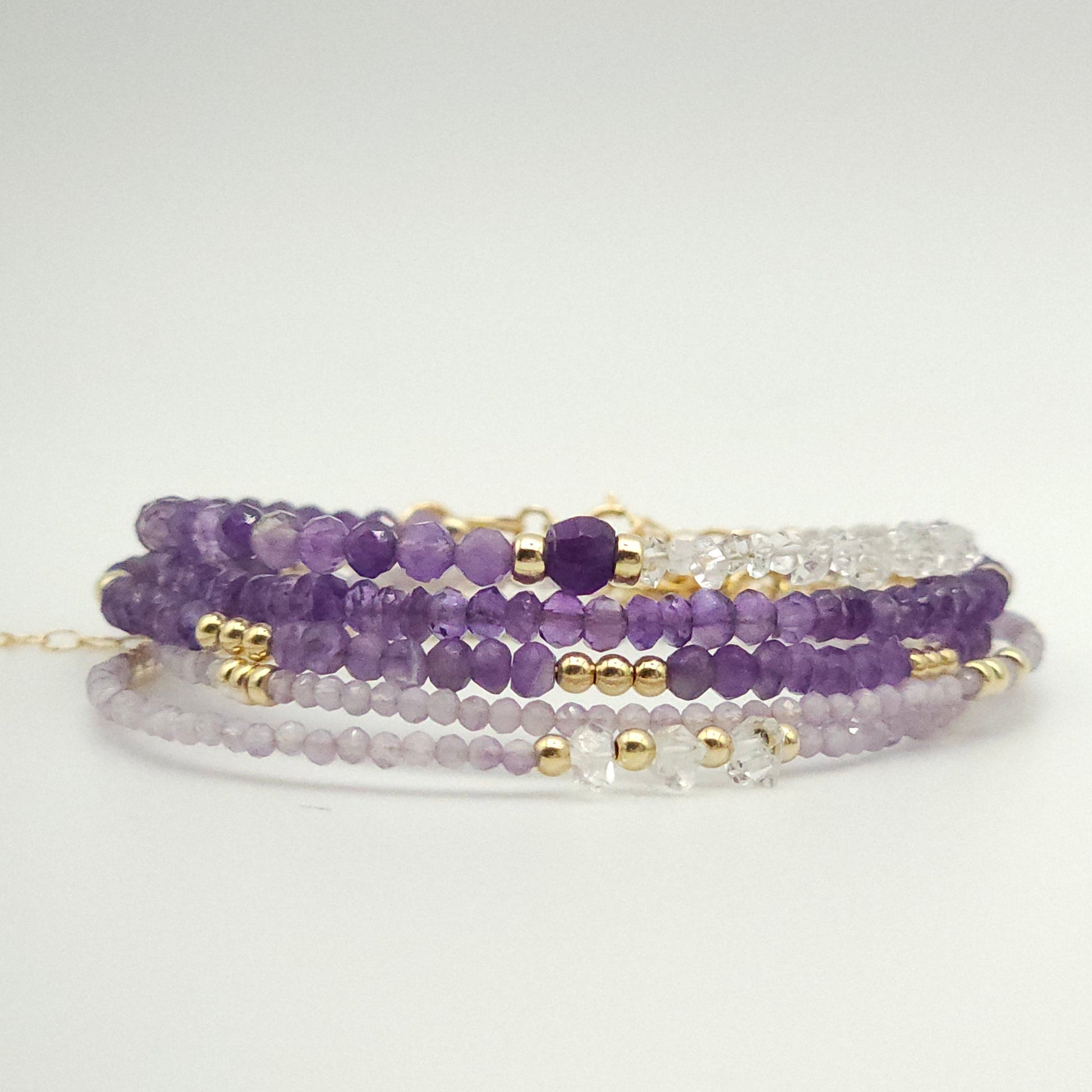 five bracelets in various amethyst beads by intentionally linked permanent jewelry. while these are not permanent jewelry, they are perfect to pair with your permanent jewelry stack. 