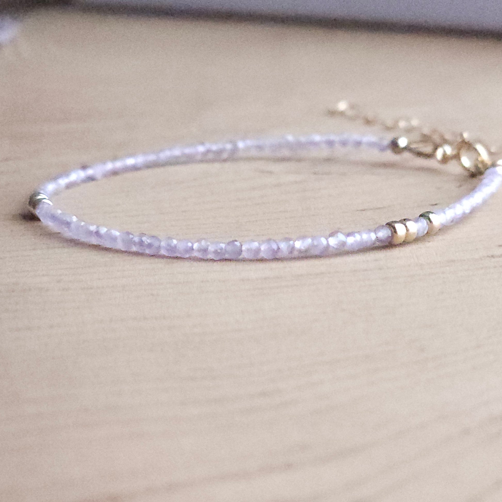 Minimalist Pink amethyst 14k gold filled beaded spring clasp bracelet  on a wood  stand by intentionally linked jewelry in baltimore 