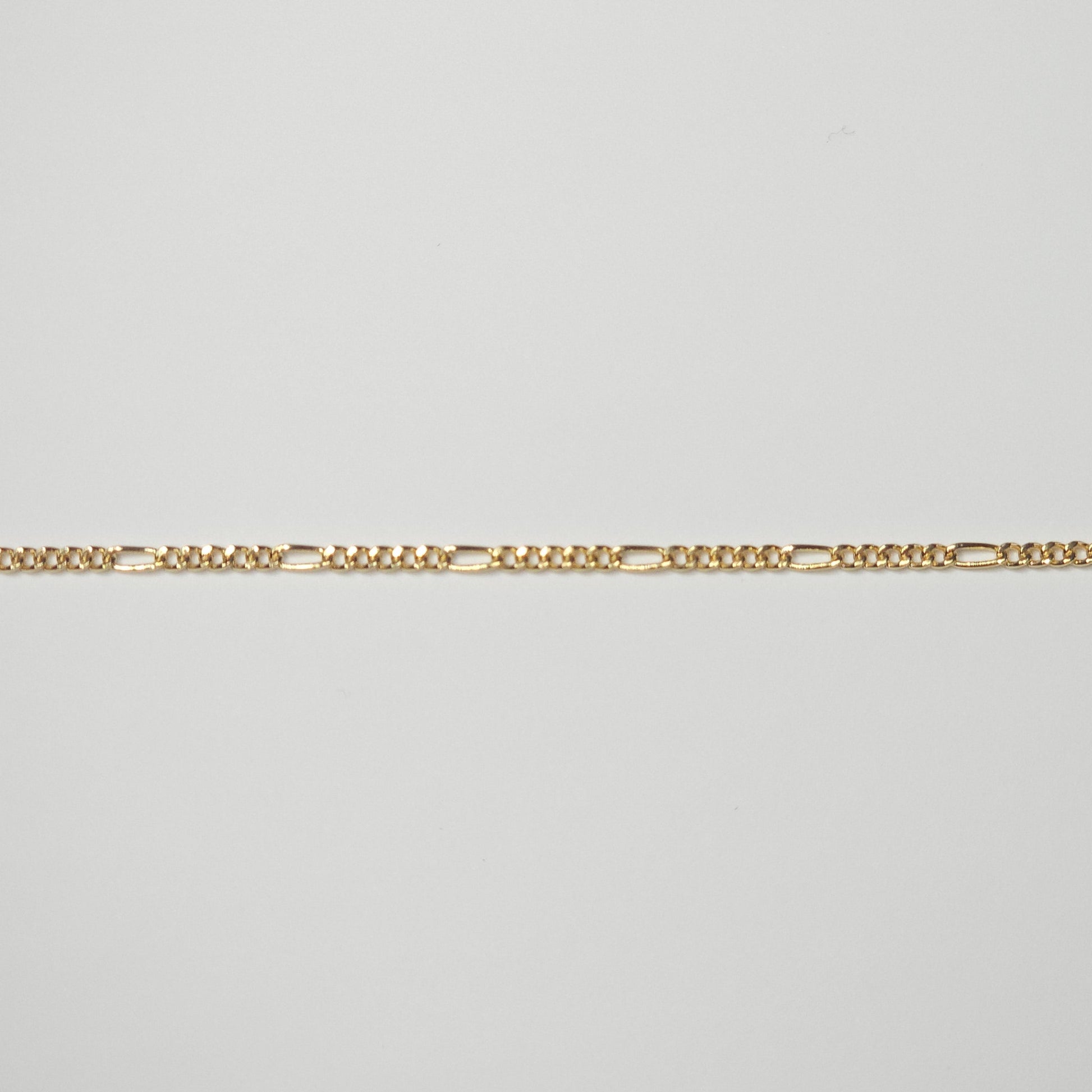 Medium-width Figaro chain in durable gold filled metal, with reflective links that combine timeless Italian styling and spiritual symbolism.