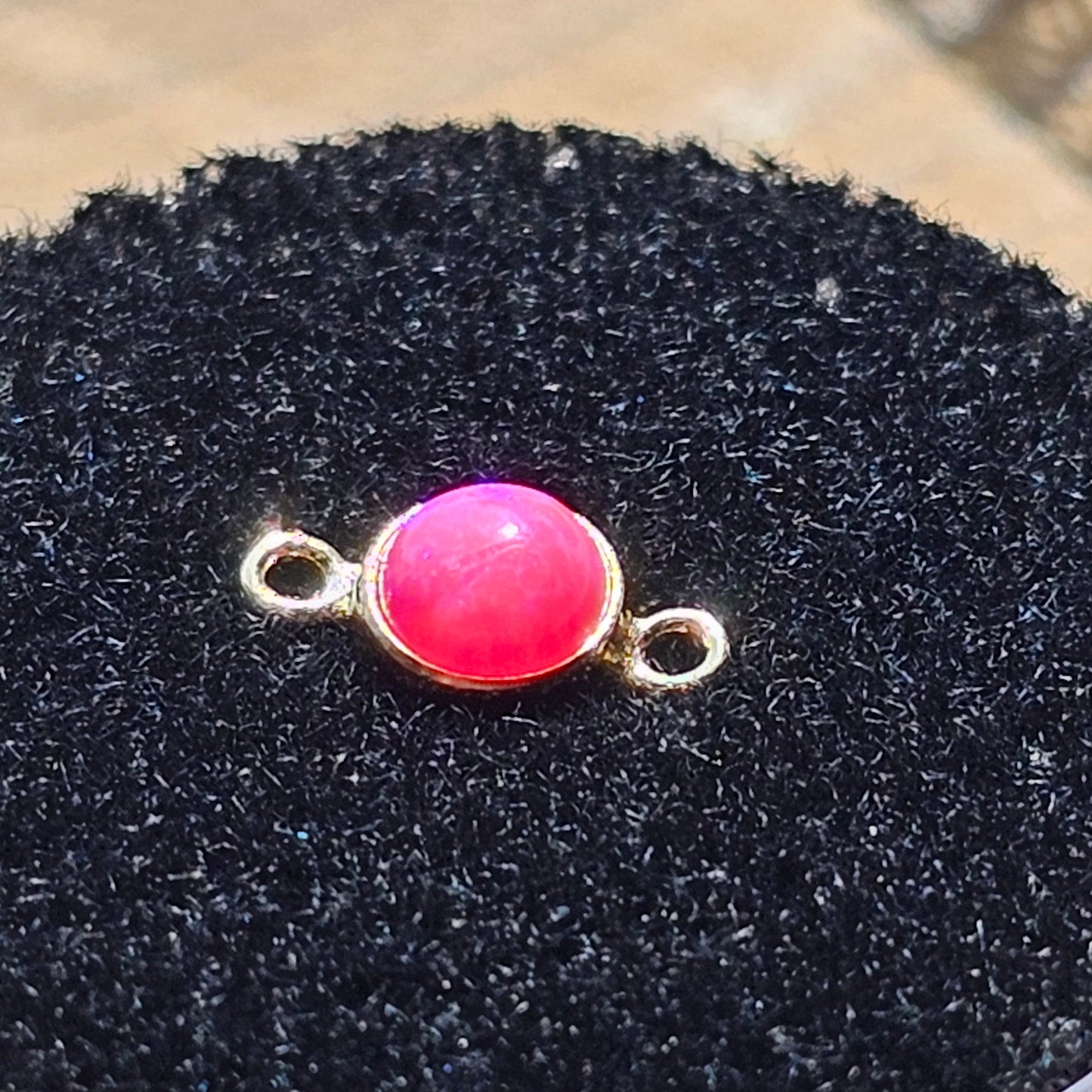 Pink connector for permanent jewelry Appointment in Baltimore Maryland. the pink opal sits in a foam container 
