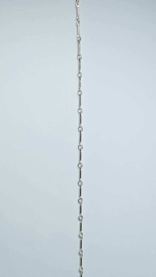A sterling silver bar link chain, bracelet, anklet, necklace with a repeating pattern of slender bars and delicate round connectors.